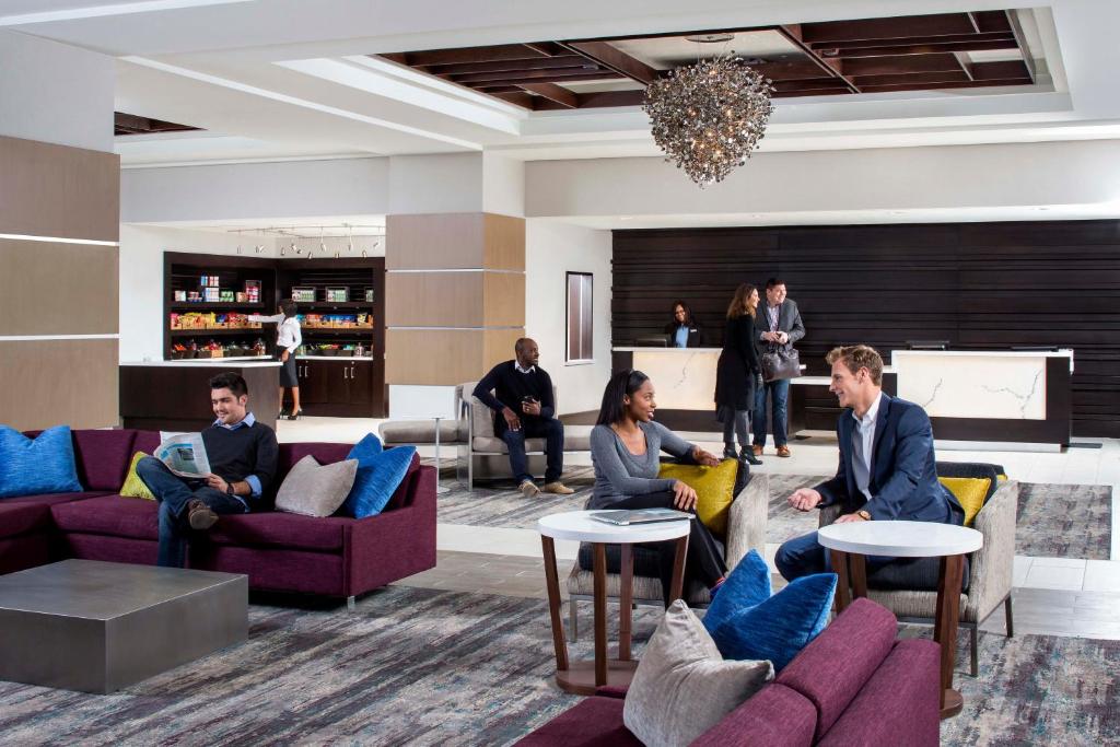 a lobby with people sitting on couches and tables at Crowne Plaza Atlanta Midtown, an IHG Hotel in Atlanta
