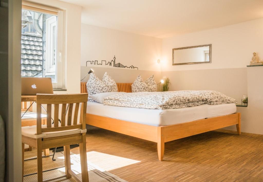 a bedroom with a bed and a desk with a laptop at Altstadt Apartment Centralissimo in Düsseldorf