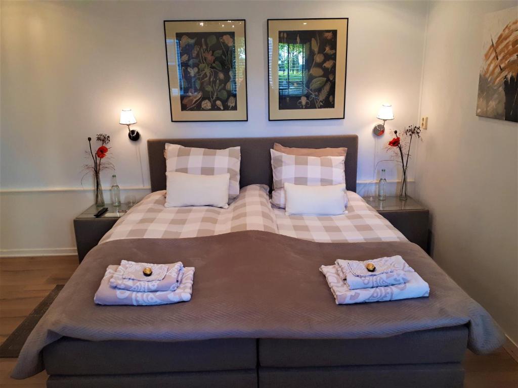 B&B de Panheide في Hooghalen: غرفة نوم بسرير كبير عليها مناشف
