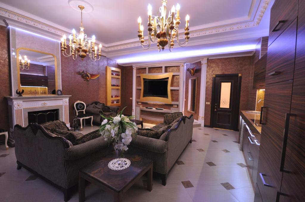 a living room with two couches and a television at Terrace Garden Seaside Apartments in Odesa