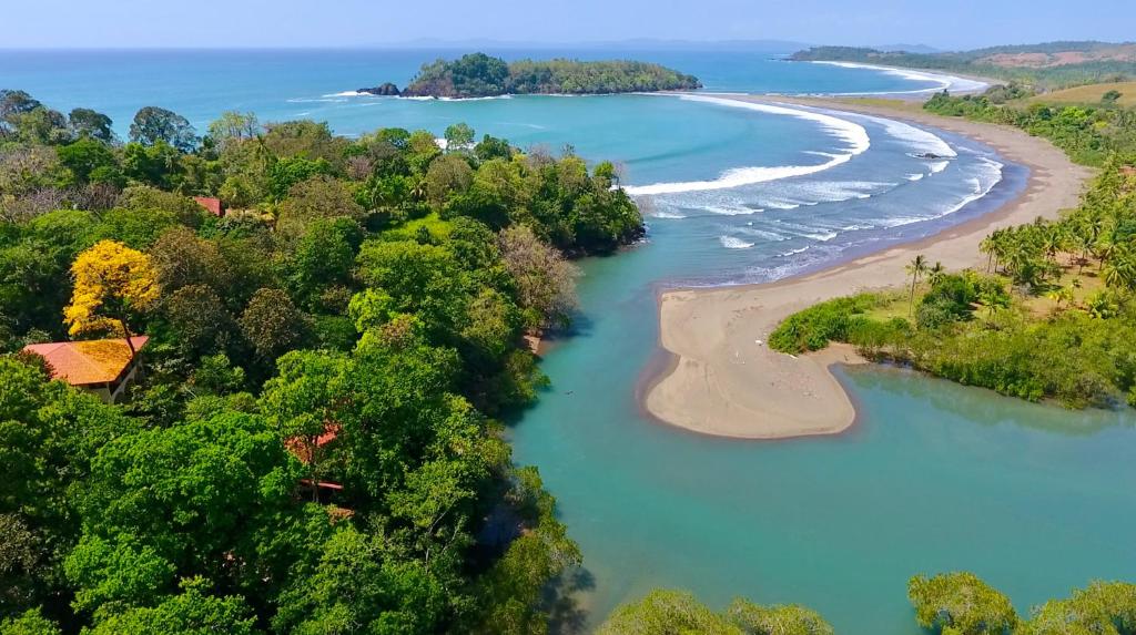 eine Luftansicht auf einen Fluss und einen Strand in der Unterkunft Morrillo Beach Eco Resort in Morrillo