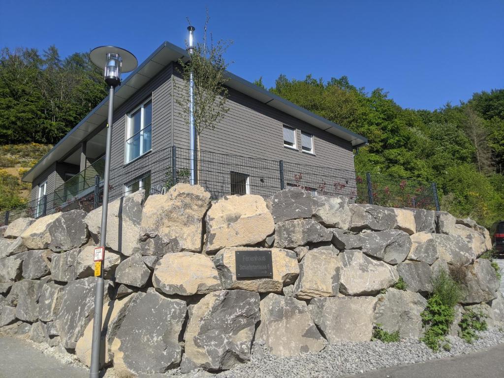 un muro di pietra di fronte a una casa di Ferienhaus Schieferterrasse - Waldsee Rieden - a Rieden