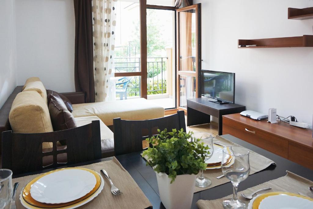 uma sala de estar com uma mesa de jantar e um sofá em Apartcomplex Sveti Vlas Victorio 2 em Sveti Vlas