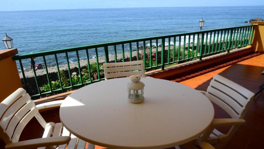 Biały stół i krzesła na balkonie z widokiem na ocean w obiekcie La Casa Grande w mieście Valle Gran Rey