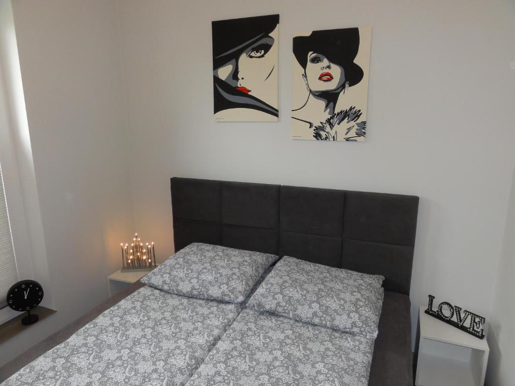 um quarto com uma cama com duas fotografias na parede em Kwatery prywatne Lotnicza em Bielsko-Biala
