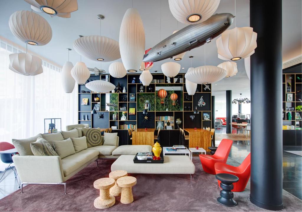 un soggiorno con divano, tavolo e sedie di citizenM Paris Charles de Gaulle Airport a Roissy en France