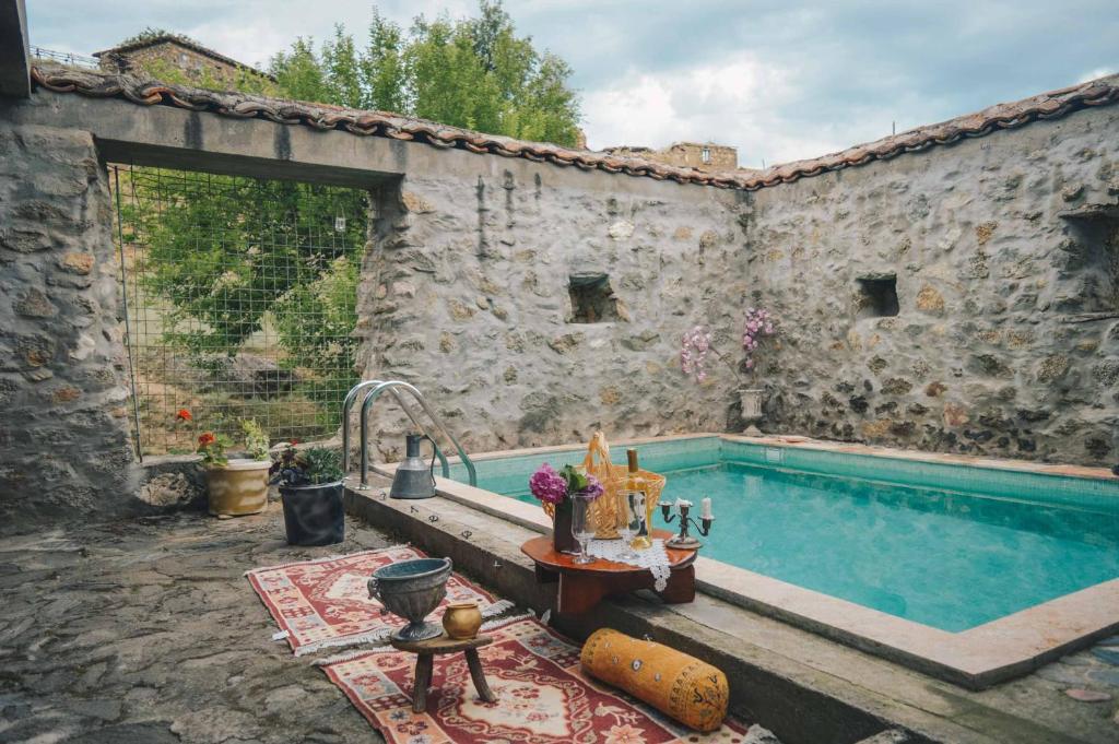 an outdoor swimming pool in a stone building at Rancho i Vancho na Kata in Omorani