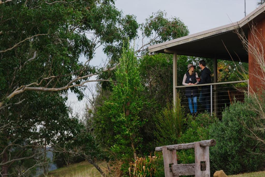 zwei Personen stehen auf einem Balkon eines Hauses in der Unterkunft Barrington Hideaway- River Cottages in Gloucester