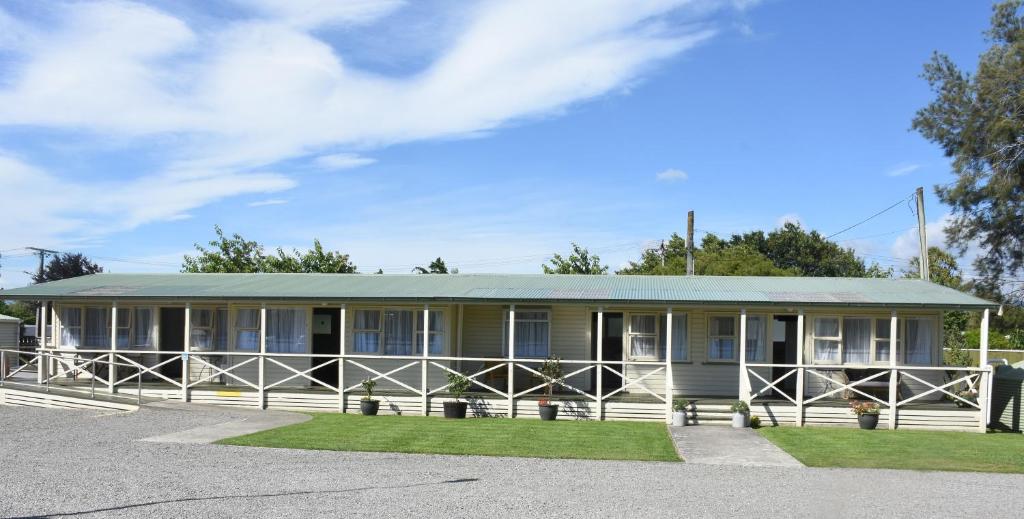 a house with a green roof on a street at Featherston Motels And Camping in Featherston