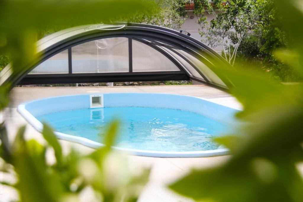 uma pequena piscina com uma ponte num quintal em Lusi house em Sveti Filip i Jakov
