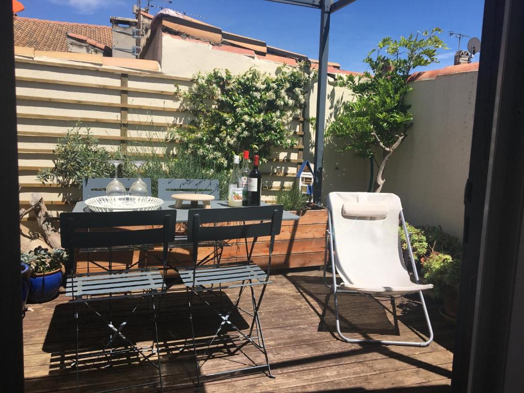 アルルにあるMaison avec terrasse à Arles, Provenceのパティオ(テーブル、椅子2脚、パラソル付)