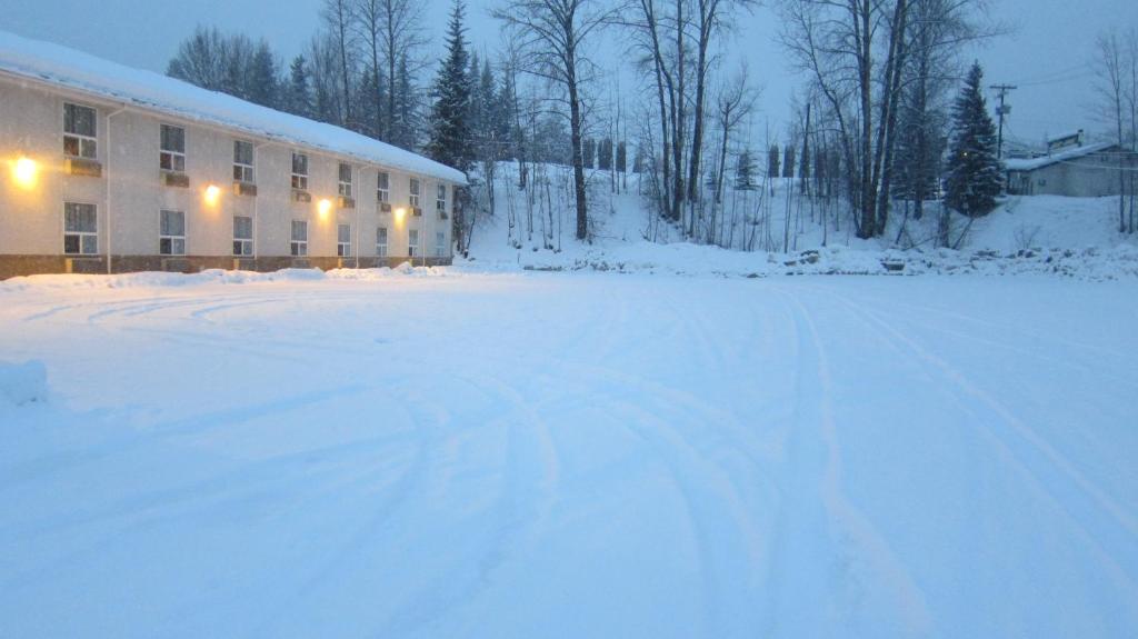 a snow covered parking lot in front of a building at Super 8 by Wyndham Revelstoke BC in Revelstoke
