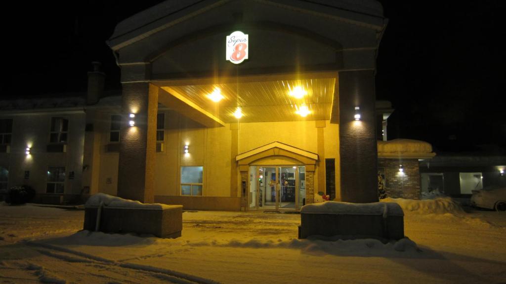 a yellow building in the snow at night at Super 8 by Wyndham Revelstoke BC in Revelstoke