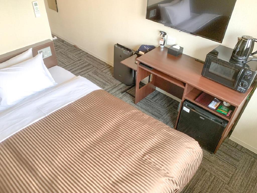 Postel nebo postele na pokoji v ubytování HOTEL LiVEMAX Hiroshima Peace Park Mae