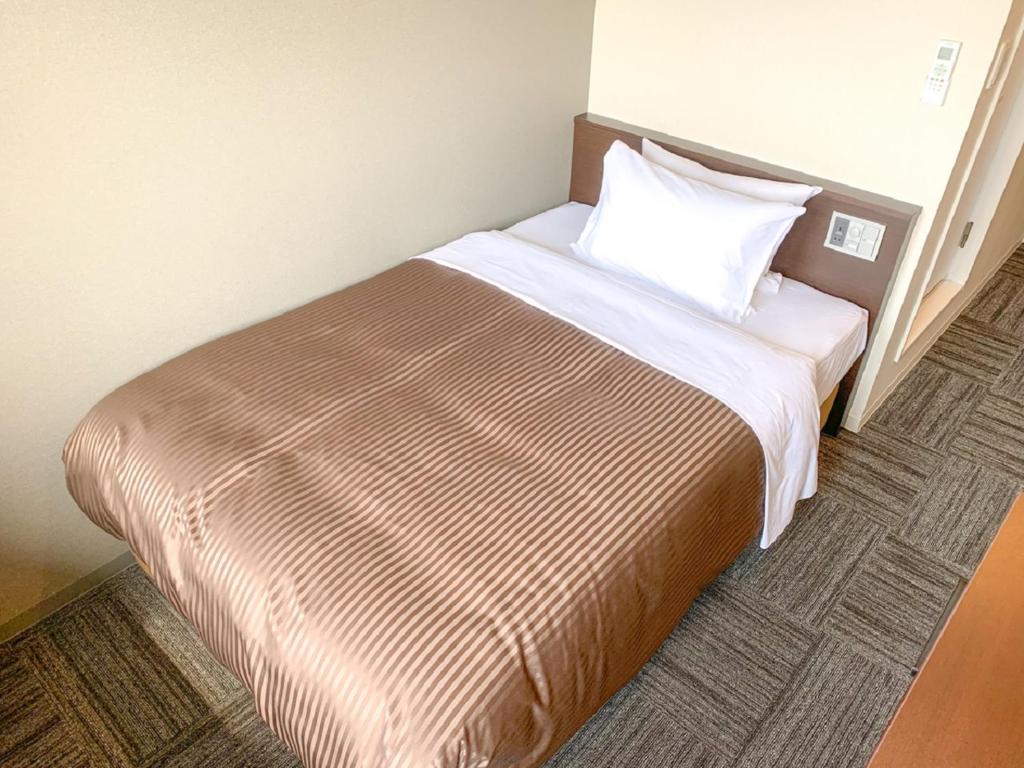 Postel nebo postele na pokoji v ubytování HOTEL LiVEMAX Hiroshima Peace Park Mae