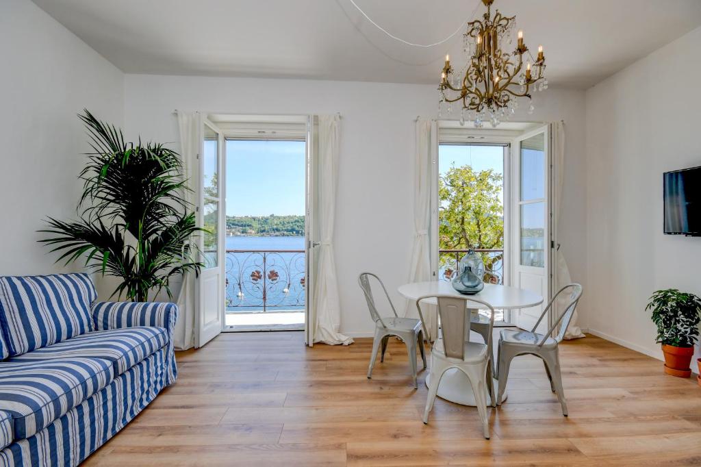 salon ze stołem, krzesłami i kanapą w obiekcie BELLAVISTA - Garda Leisure w mieście Salò