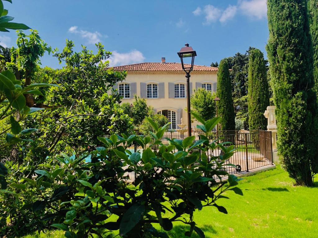une grande maison avec un portail et des arbres dans l'établissement Villa Agrippa, à Orange