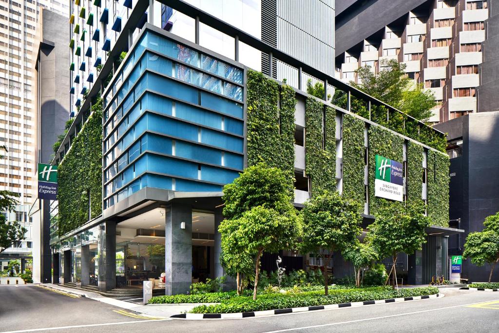 ein blaues Gebäude mit nebenstehenden Pflanzen in der Unterkunft Holiday Inn Express Singapore Orchard Road, an IHG Hotel in Singapur