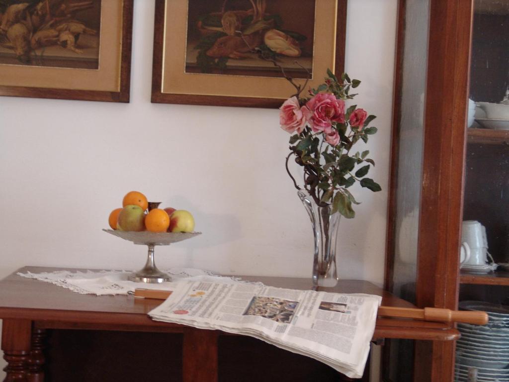 einen Tisch mit einer Blumenvase und einer Zeitung in der Unterkunft Rapallo Mare in Rapallo