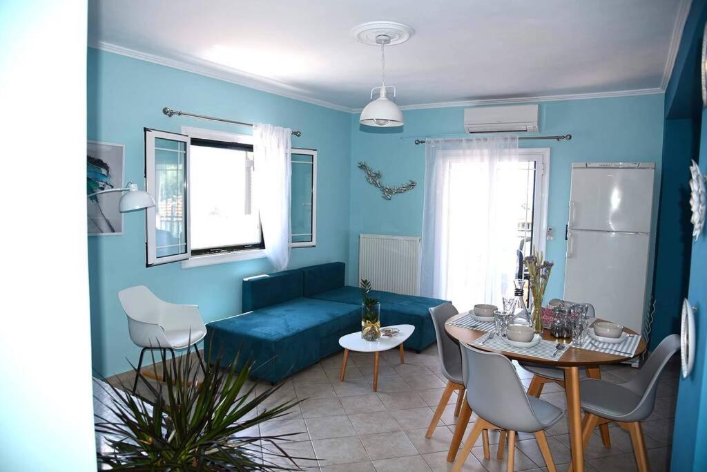een woonkamer met een blauwe bank en een tafel bij Pogonia Sea View Apartment in Pogoniá