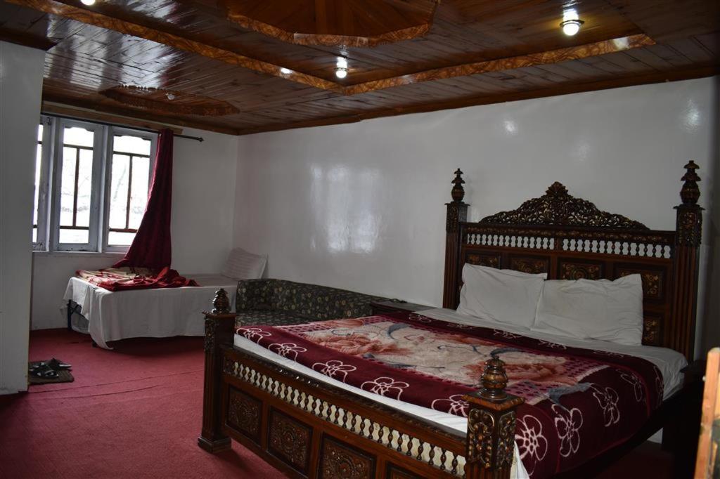 1 dormitorio con 1 cama grande con marco de madera en Track View Hotel, en Murree