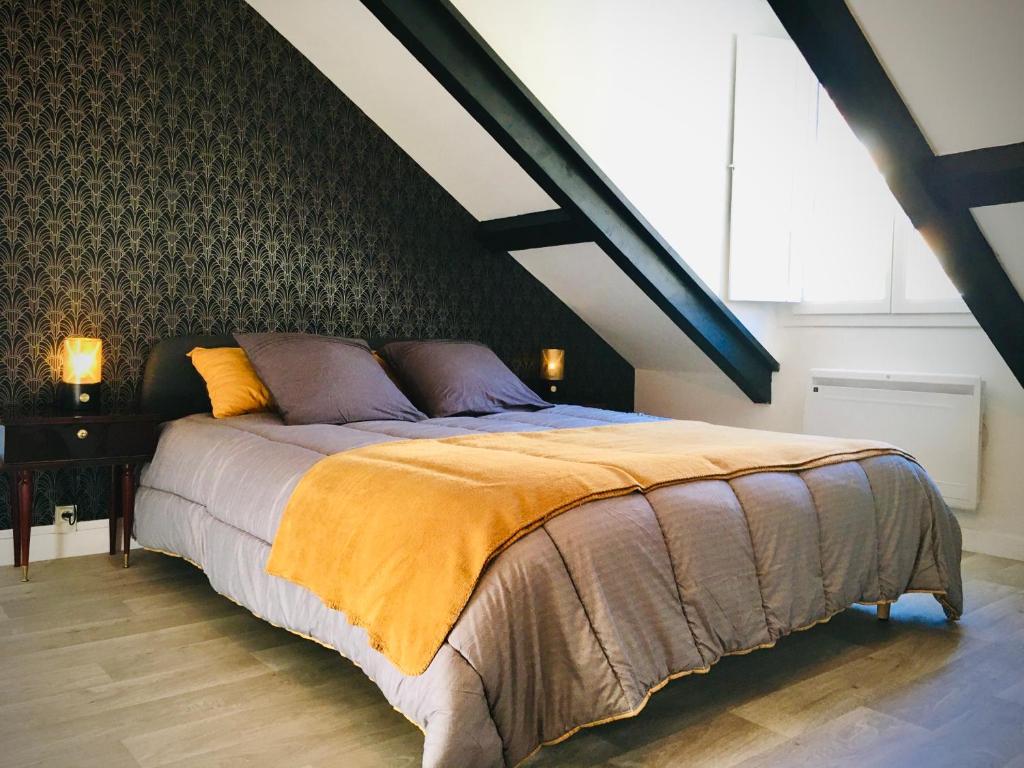 sypialnia z dużym łóżkiem na poddaszu w obiekcie PYRENE HOLIDAYS 4 étoiles spacieux dans immeuble atypique proche des thermes et des Pyrénées w mieście Capvern