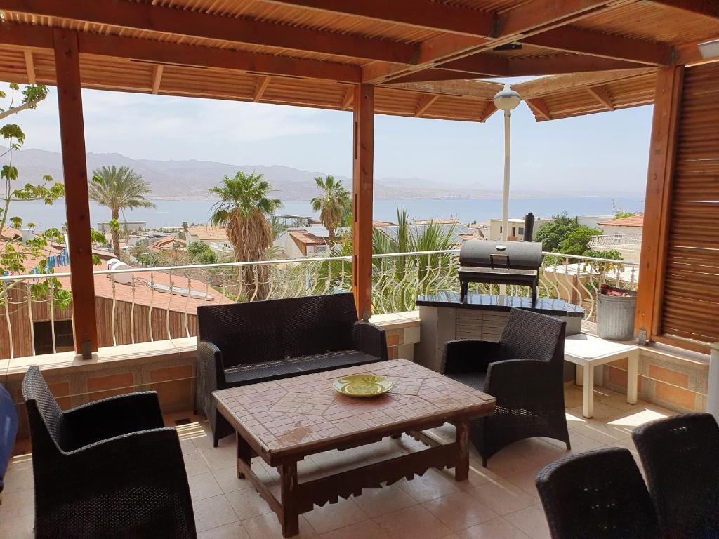 eine Terrasse mit einem Tisch, Stühlen und einem Grill in der Unterkunft Shefer Guesthouse in Eilat