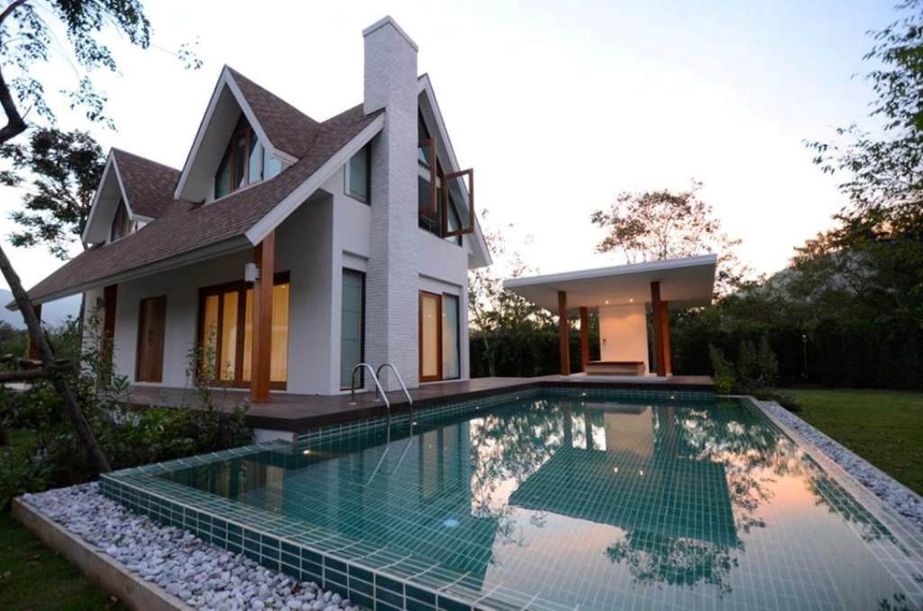 a house with a swimming pool in front of a house at Prairie Hills Resort in Mu Si