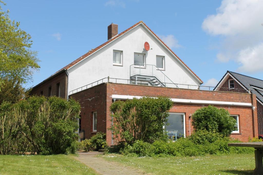 ein Backsteingebäude mit einem Fenster darüber in der Unterkunft Apartmenthaus Seestern in Neßmersiel