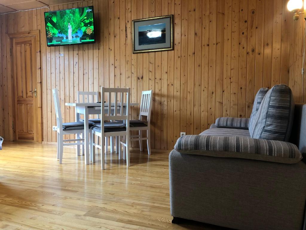 a dining room with a table and chairs and a couch at Cunami in Nida