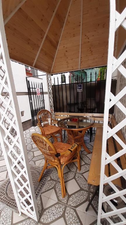 a patio with a table and chairs on a tile floor at Vila Ada in Bucharest