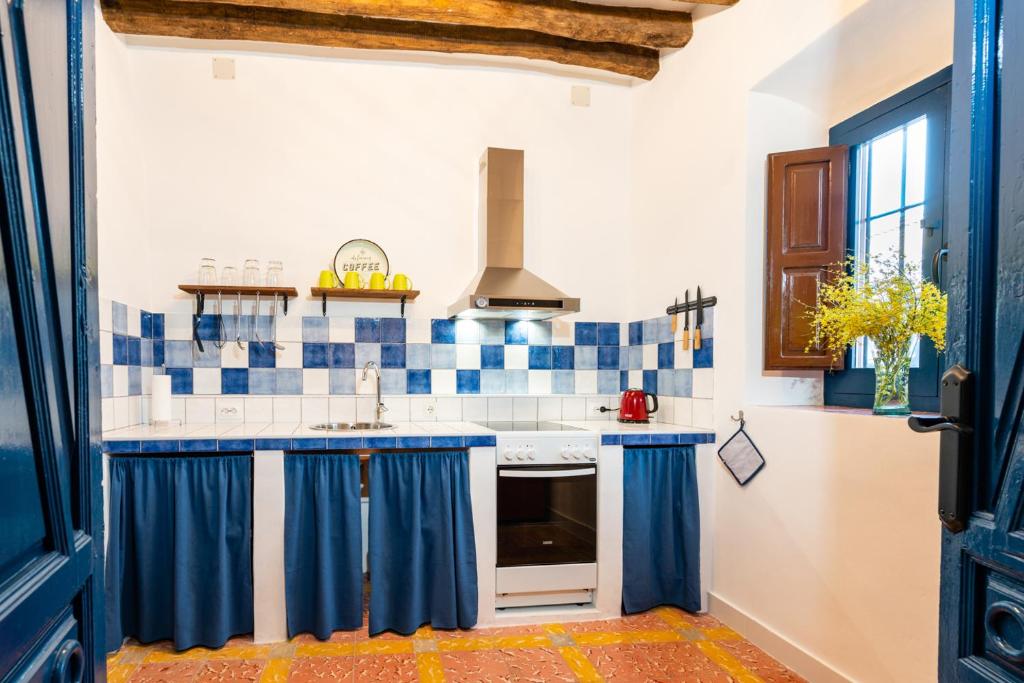 cocina con azulejos azules y blancos en la pared en Limonero bnb, en Gualchos