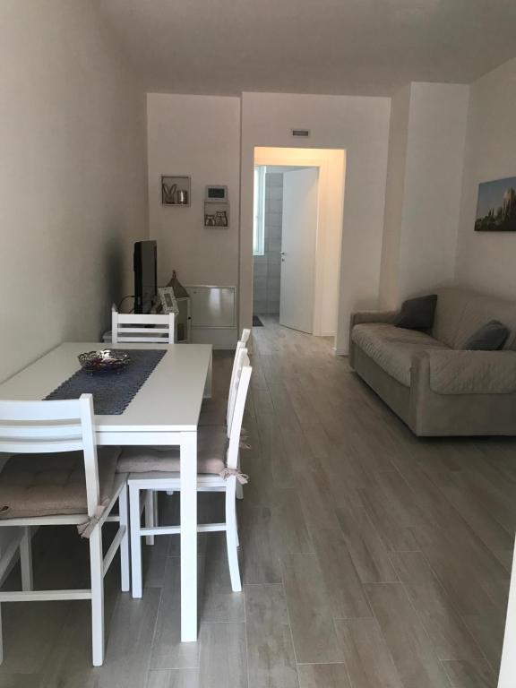 een woonkamer met een tafel en stoelen en een bank bij Appartamento Marte in Arco