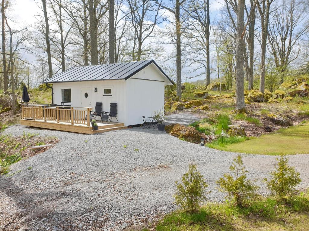 Cette petite maison blanche dispose d'une terrasse couverte. dans l'établissement Humlegarden lake cottage, Horn, à Horn
