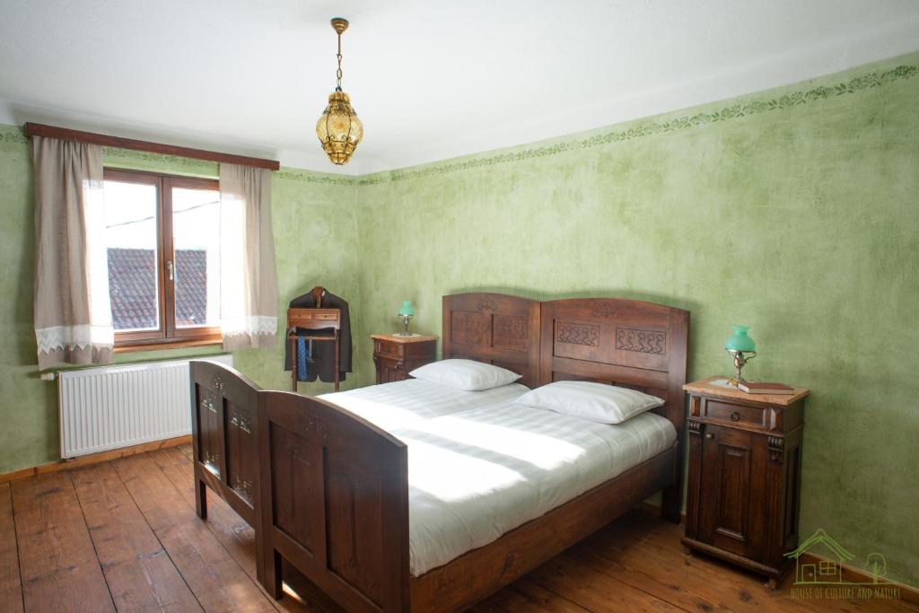 a bedroom with a large bed with green walls at House of Culture and Nature - Hiša Kulture in Nature in Zagradec