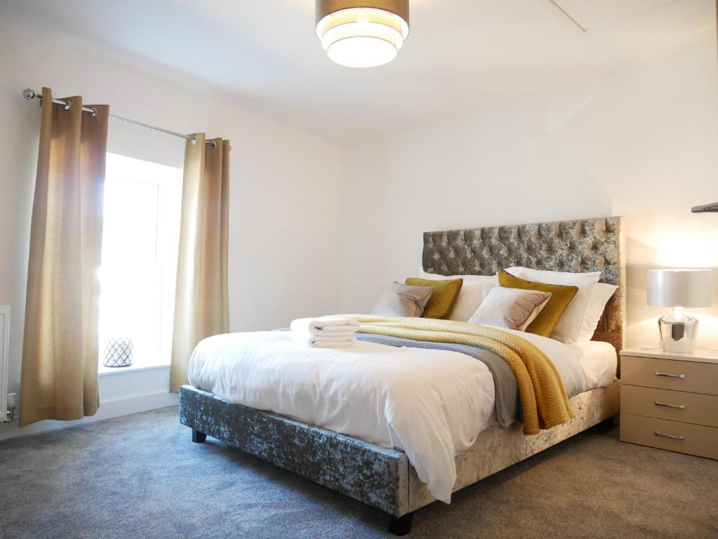 a bedroom with a large bed and a window at Gill Gardens Penthouse, Ulverston in Ulverston