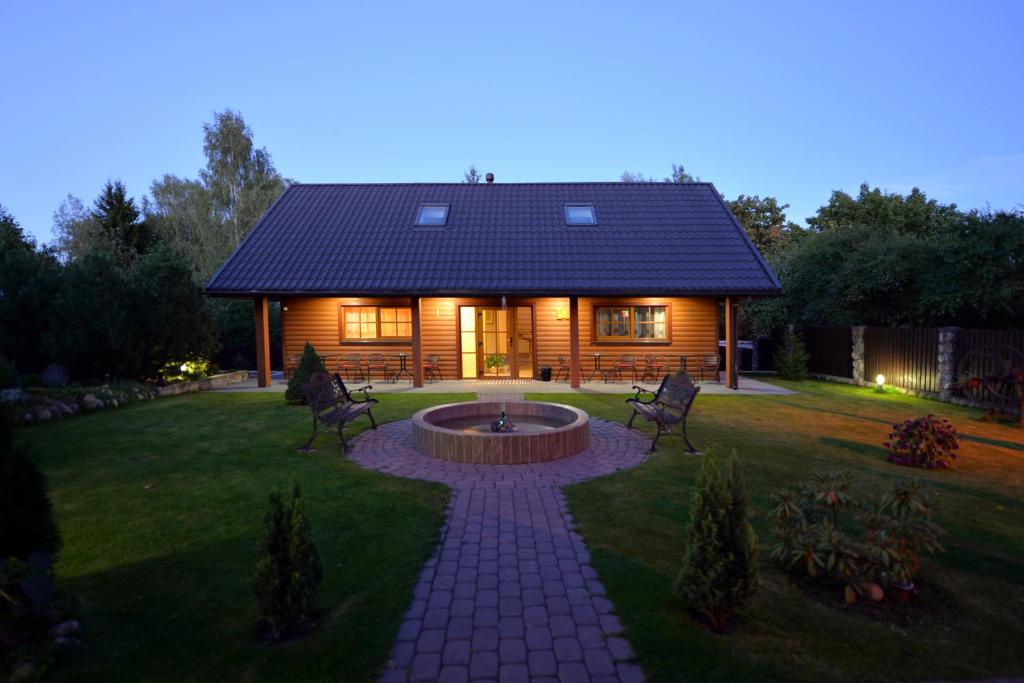 una cabaña de madera con una hoguera en el patio en "Trakaitis" nameliai, en Trakai