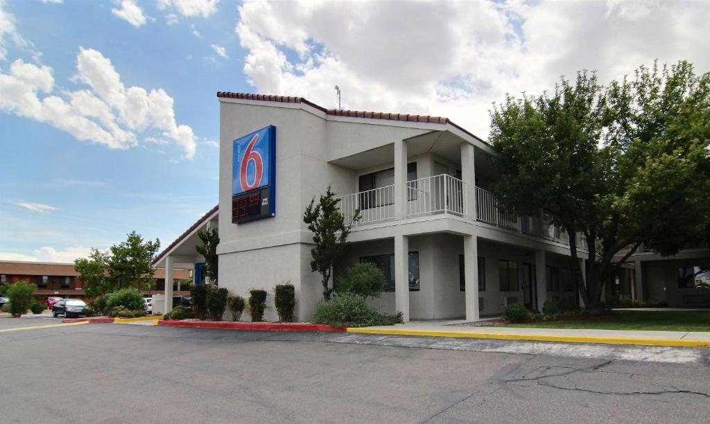 un edificio blanco con un cartel en el costado en Motel 6-Albuquerque, NM - Coors Road, en Albuquerque