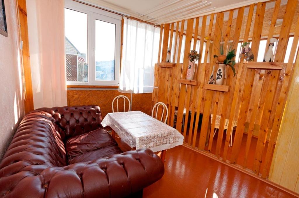 a living room with a leather couch and a table at Guest House Zhelannyi in Feodosia