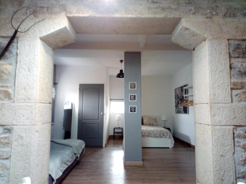 Habitación con 2 camas y pared de piedra. en Le Gîte du haut en Châtillon-la-Palud