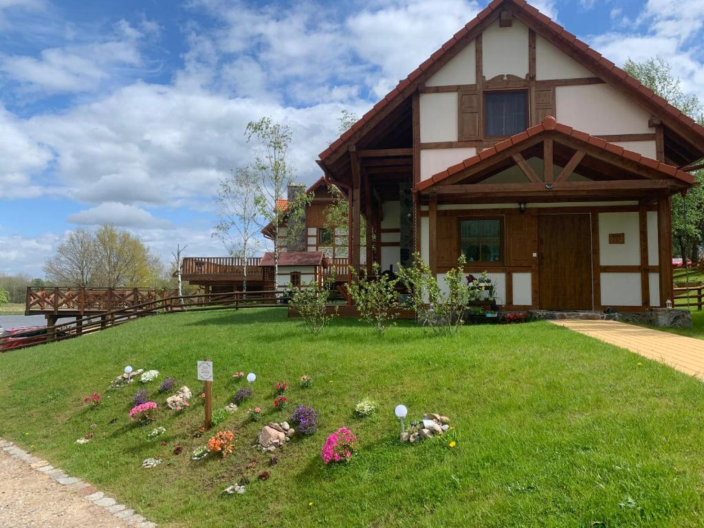 Ein Haus mit einem Blumenstrauß im Hof. in der Unterkunft Nasze Zacisze Osiedle Kaszubska Ostoja in Barkocin