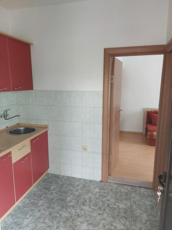 una cocina con fregadero y una puerta a una habitación en Vila Jovana, en Sutomore