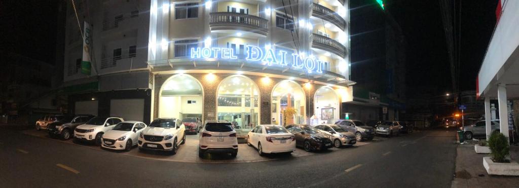 uma fila de carros estacionados em frente a um edifício em NGỌC MẤY - ĐẠI LỢI HOTEL em Chau Doc