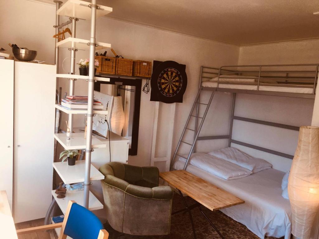 a dorm room with a bunk bed and a chair at Nice room in apartment in Amager in Copenhagen