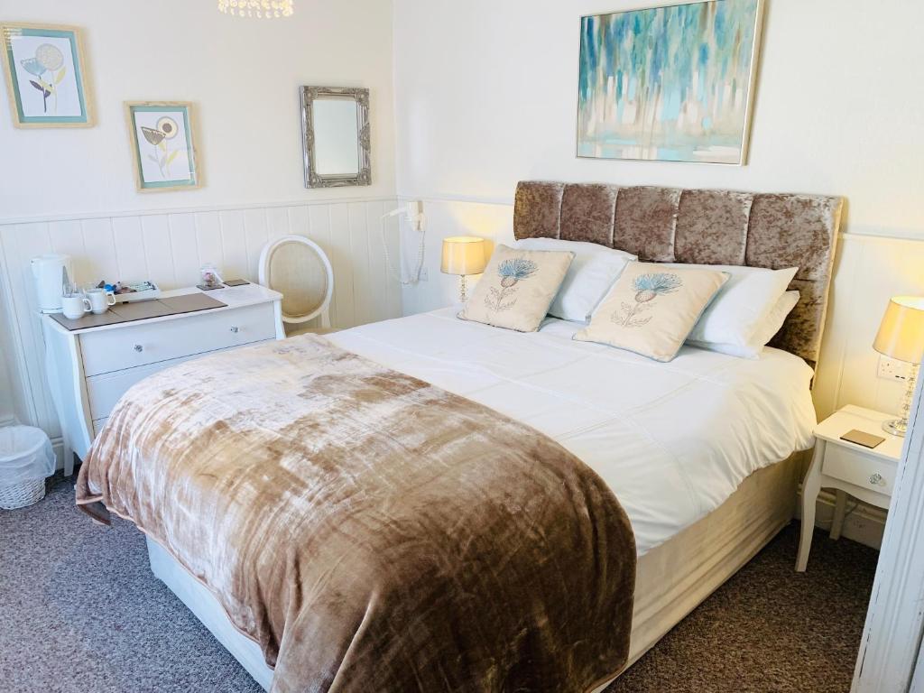 a bedroom with a large bed and a night stand at Cambrian House in Llangollen