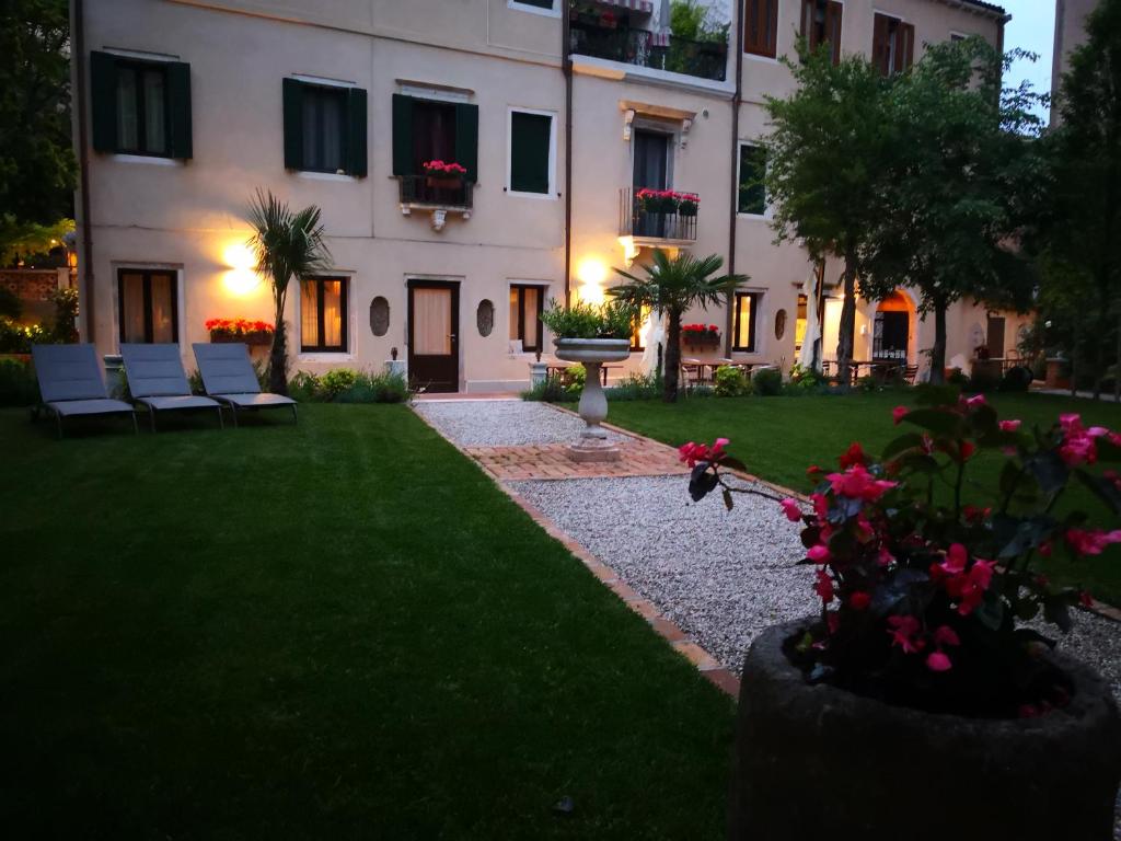 un gran edificio blanco con sillas en un patio en Cinqueteste Luxury Home en Venecia