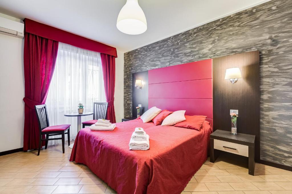 1 dormitorio con cama roja y mesa con silla en Dreams Of Rome, en Roma