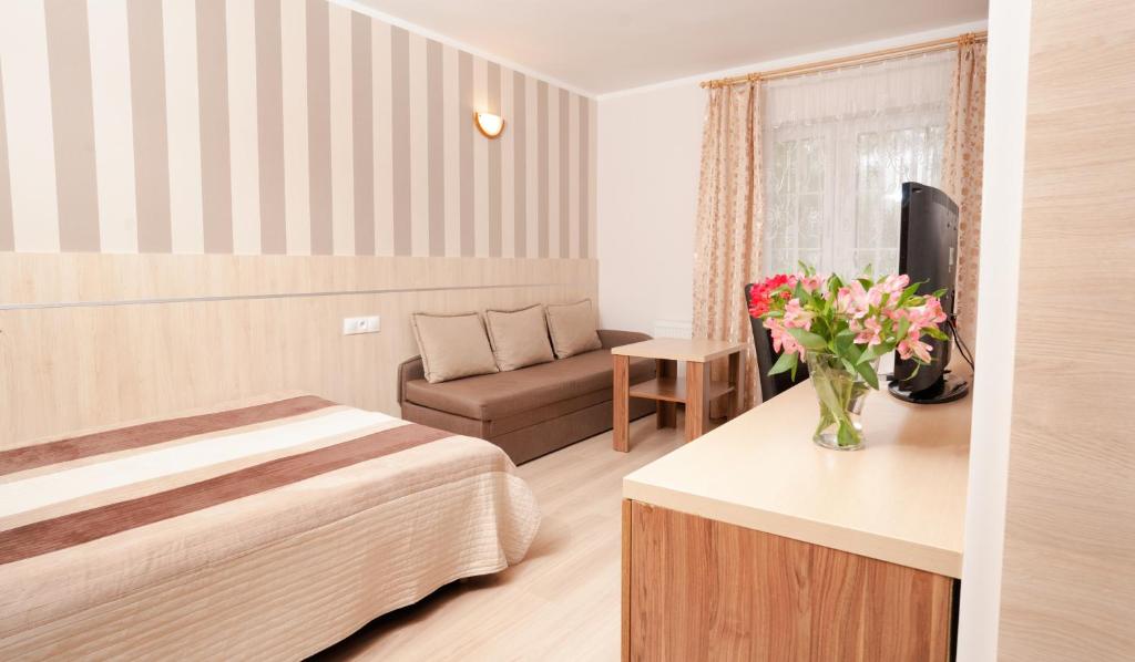 una habitación de hotel con una cama y un sofá en RizaVilla, en Krynica Morska