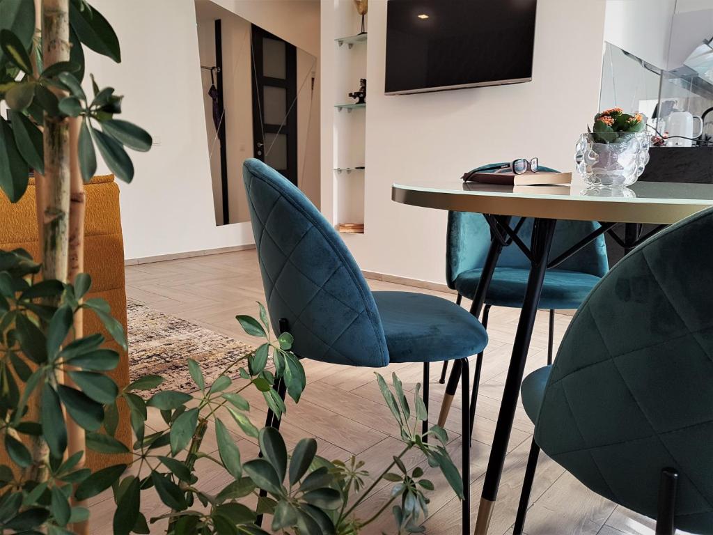 une salle à manger avec des chaises bleues et une table dans l'établissement Apartment For You, à Šiauliai