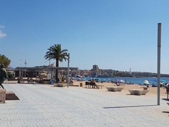 ein Strand mit Tischen und Stühlen und Menschen am Strand in der Unterkunft Fréjus plage in Fréjus